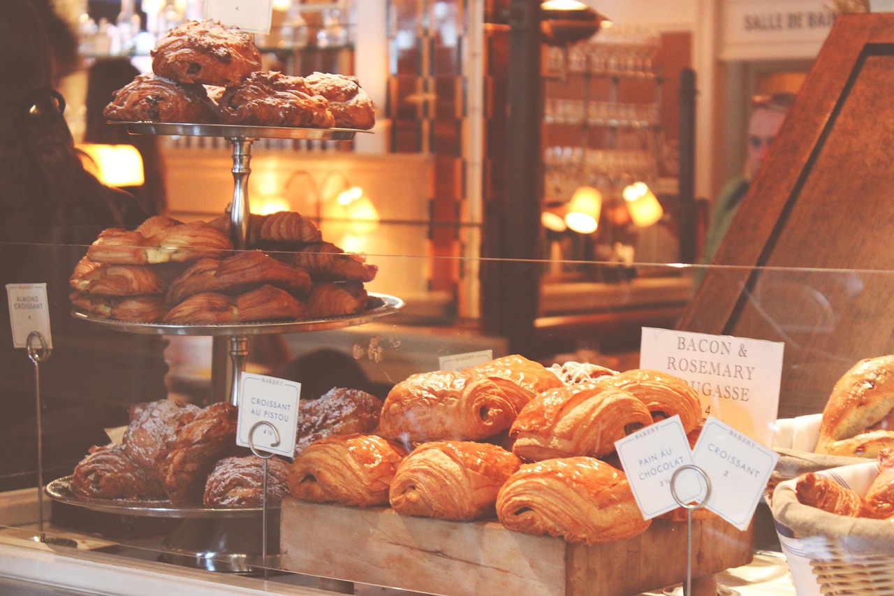 A bakery case full of golden croissants and pastries.